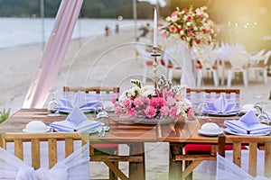 Romantic dinning table on the beach . Table setting at a luxury wedding and Beautiful flowers on the table.