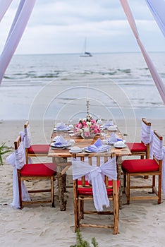 Romantic dinning table on the beach . Table setting at a luxury wedding and Beautiful flowers on the table.