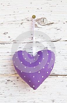 Romantic dotted heart shape hanging above white wooden surface o