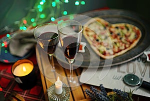 Romantic evening with candles, wine, heart shaped Pizza. Love. St Valentin's Day. Holidays celebration.