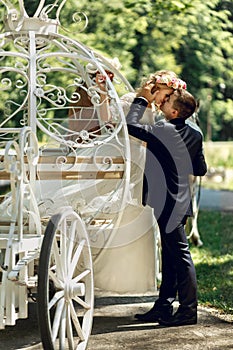 Romantic fairy-tale wedding couple bride and groom kissing in ma