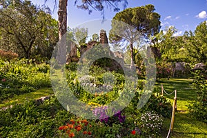 The romantic garden of Ninfa with ruins and flowers photo