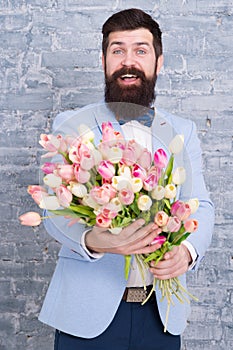 Romantic gift. Macho getting ready romantic date. Waiting for darling. Tulips for sweetheart. Man well groomed wear