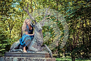 Romantic girl in dirndl sitting on the deer