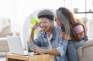 Romantic girl distracting boyfriend who work as freelancer at home