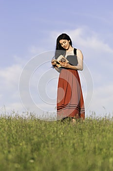 Romantic Girl Reading a Book on a Hill