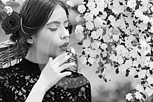 Romantic girl or young woman with white flower in mouth. Spring and summer. Nature beauty.