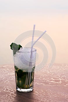 Romantic glass of cocktails Standing on the beach at colorful sunset