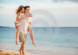 Romantic happy couple on the beach at sunset