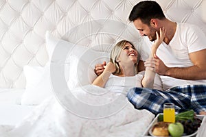 Romantic happy couple having breakfast in bed