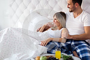 Romantic happy couple having breakfast in bed