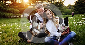 Romantic happy couple in love enjoying their time with pets in nature