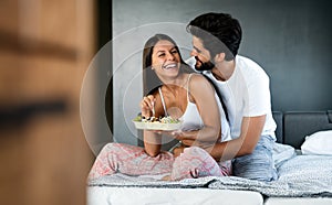 Romantic happy couple in love having breakfast in bed