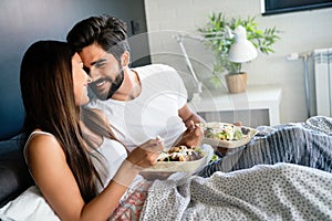 Romantic happy couple in love having breakfast in bed