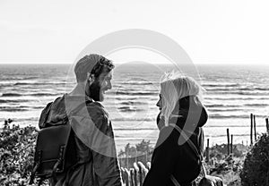 Romantic happy couple in love standing on wooden stairs on dunes at the wild beach in front of the sea - Boyfriend and girlfriend