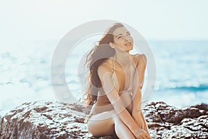 Portrait of beautiful young woman on wild rocky beach.