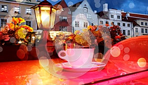 Romantic holiday city light Street cafe  bokeh blurring city light evening restaurant table cup of coffee on top view candle lamp