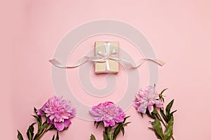 Romantic holiday composition with gift box with silk ribbon and pink peone. Mother`s day concept