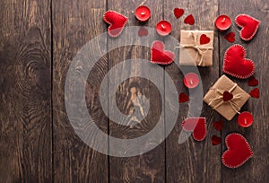 Romantic image for valentine`s day red hearts, candles and bright gifts on wooden background