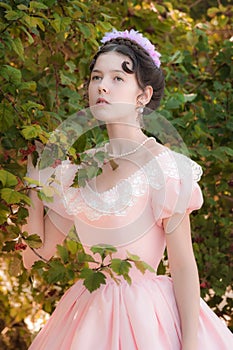 Romantic innocent girl in an evening dress in the garden