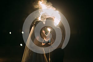 Romantic kiss just married couple in front of flaming heart. Night shot