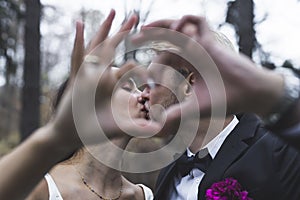 Romantic kiss between just married couple - Middle Eastern Ethnic Bride and Caucasian Groom. Blurred hands creating