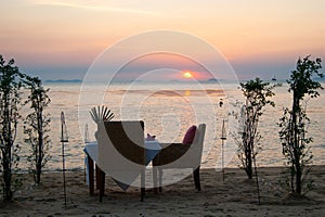 Romantic little table on the seashore, with candles.