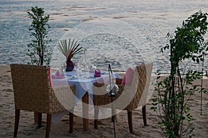 Romantic little table on the seashore, with candles.