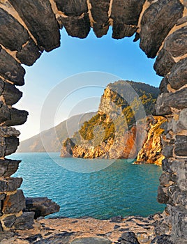 Romantic look at Portovenere on mediterranean sea through a historic medieval stone arch window. Liguria . Italy