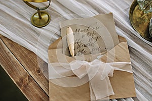 Romantic love letter. Old letter with vintage handwriting, envelope and feather pen on the table. Calligraphy. top view