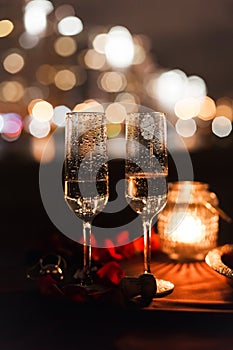 Romantic luxury evening with champagne setting with two glasses, rose petails and candles