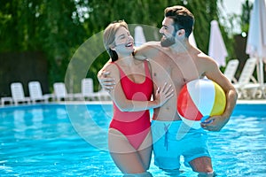 Romantic man embracing his female companion in the swimming pool
