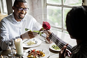 Romantic Man Giving a Rose to Woman on a Date