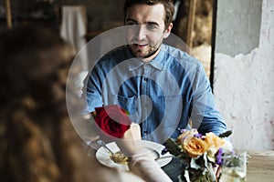 Romantic Man Giving a Rose to Woman on a Date