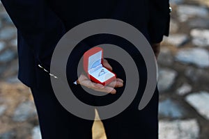 romantic man making a marriage proposal. picture of man with gift box in suit. picture of couple with wedding ring and gift box.