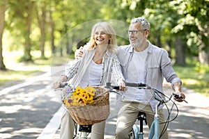 Romantic Mature Spouses Having Fun While Riding Bicycles In Park