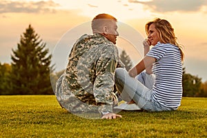 Romantic meeting of soldier and his girlfriend outdoor.