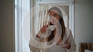 Romantic model drinking cappuccino morning closeup. Relaxed girl looking window