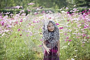 Romantic moment of asian kid breezing on daisy flower agriculture field photo