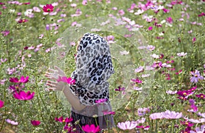 Romantic moment of asian kid breezing on daisy flower agriculture field photo