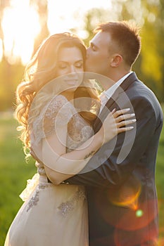 Romantic moments of a young wedding couple on summer meadow