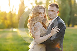 Romantic moments of a young wedding couple on summer meadow