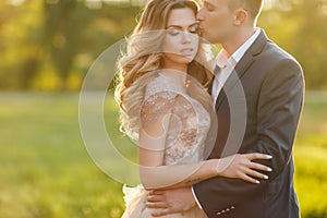 Romantic moments of a young wedding couple on summer meadow
