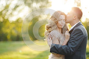 Romantic moments of a young wedding couple on summer meadow