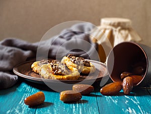 Romantic morning still life, in a rustic style with cookies, a glass jar of honey and scattered dates on a turquoise wooden