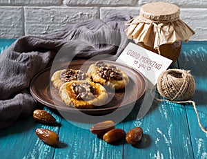 Romantic morning still life in a rustic style with cookies, honey and dates on a turquoise wooden background