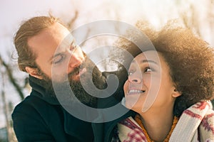 Romantic multiethnic couple in love hugging on the street