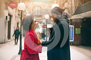 Romantic multiethnic couple in love hugging on the street