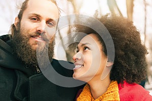 Romantic multiethnic couple in love hugging on the street