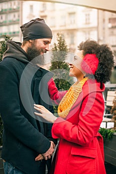 Romantic multiethnic couple in love hugging on the street